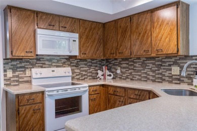 Escape to a peaceful, tree-lined oasis in this beautifully on Palm Harbor Golf Club in Florida - for sale on GolfHomes.com, golf home, golf lot