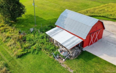 This picture perfect farmhouse sits nestled in the fields at the on Hiawatha Sportsmans Golf Club in Michigan - for sale on GolfHomes.com, golf home, golf lot