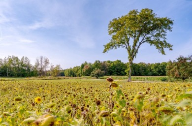 This picture perfect farmhouse sits nestled in the fields at the on Hiawatha Sportsmans Golf Club in Michigan - for sale on GolfHomes.com, golf home, golf lot