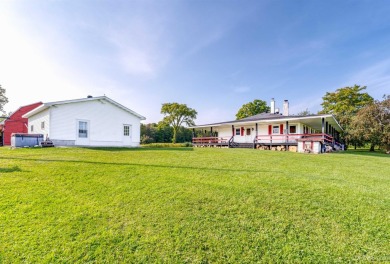 This picture perfect farmhouse sits nestled in the fields at the on Hiawatha Sportsmans Golf Club in Michigan - for sale on GolfHomes.com, golf home, golf lot