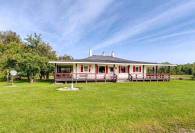 This picture perfect farmhouse sits nestled in the fields at the on Hiawatha Sportsmans Golf Club in Michigan - for sale on GolfHomes.com, golf home, golf lot