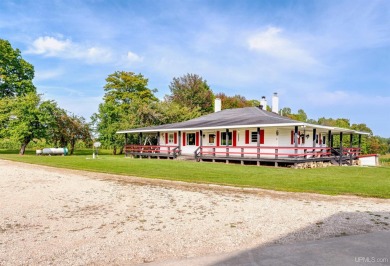 This picture perfect farmhouse sits nestled in the fields at the on Hiawatha Sportsmans Golf Club in Michigan - for sale on GolfHomes.com, golf home, golf lot