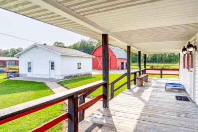 This picture perfect farmhouse sits nestled in the fields at the on Hiawatha Sportsmans Golf Club in Michigan - for sale on GolfHomes.com, golf home, golf lot