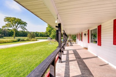 This picture perfect farmhouse sits nestled in the fields at the on Hiawatha Sportsmans Golf Club in Michigan - for sale on GolfHomes.com, golf home, golf lot