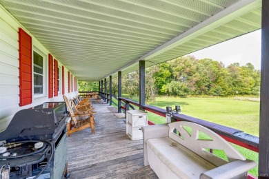 This picture perfect farmhouse sits nestled in the fields at the on Hiawatha Sportsmans Golf Club in Michigan - for sale on GolfHomes.com, golf home, golf lot