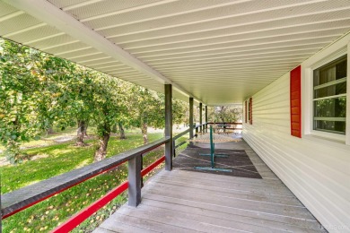 This picture perfect farmhouse sits nestled in the fields at the on Hiawatha Sportsmans Golf Club in Michigan - for sale on GolfHomes.com, golf home, golf lot