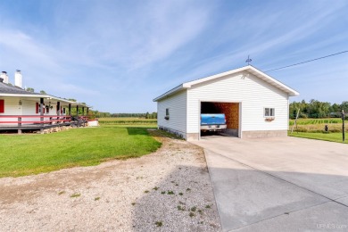 This picture perfect farmhouse sits nestled in the fields at the on Hiawatha Sportsmans Golf Club in Michigan - for sale on GolfHomes.com, golf home, golf lot