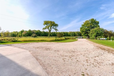 This picture perfect farmhouse sits nestled in the fields at the on Hiawatha Sportsmans Golf Club in Michigan - for sale on GolfHomes.com, golf home, golf lot