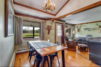 This picture perfect farmhouse sits nestled in the fields at the on Hiawatha Sportsmans Golf Club in Michigan - for sale on GolfHomes.com, golf home, golf lot