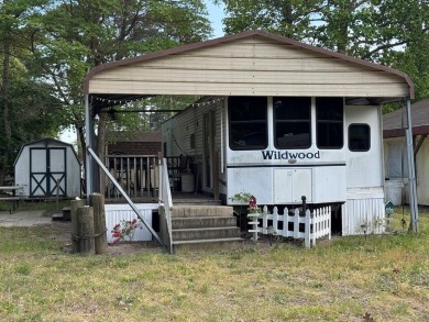 Lot with camper, camperport, deck, and shed.  Camper is in good on Captains Cove Golf and Yacht Club in Virginia - for sale on GolfHomes.com, golf home, golf lot