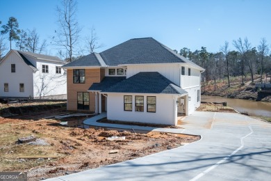 This gorgeous new construction is directly on Osprey Pointe Pond on Harbor Club Golf and Country Club in Georgia - for sale on GolfHomes.com, golf home, golf lot