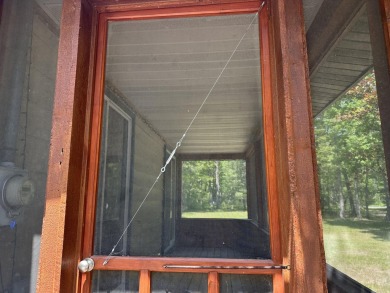 This well kept 2 bedroom is in a great location with paved road on Marquette Trails Country Club in Michigan - for sale on GolfHomes.com, golf home, golf lot