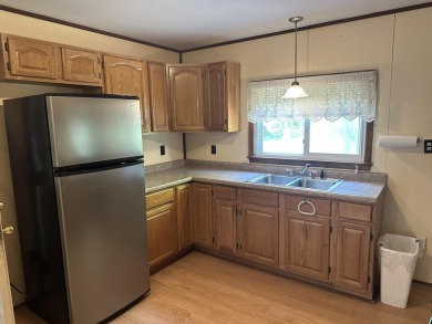This well kept 2 bedroom is in a great location with paved road on Marquette Trails Country Club in Michigan - for sale on GolfHomes.com, golf home, golf lot