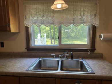 This well kept 2 bedroom is in a great location with paved road on Marquette Trails Country Club in Michigan - for sale on GolfHomes.com, golf home, golf lot