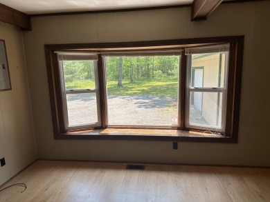 This well kept 2 bedroom is in a great location with paved road on Marquette Trails Country Club in Michigan - for sale on GolfHomes.com, golf home, golf lot