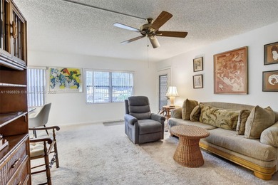Enjoy serene lake and golf course views from this first-floor on Flamingo Lakes Country Club in Florida - for sale on GolfHomes.com, golf home, golf lot
