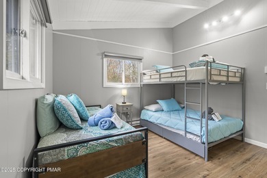 Tucked beneath a canopy of whispering trees, this modern chalet on Pocono Farms Country Club in Pennsylvania - for sale on GolfHomes.com, golf home, golf lot