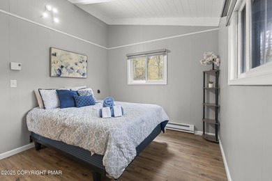 Tucked beneath a canopy of whispering trees, this modern chalet on Pocono Farms Country Club in Pennsylvania - for sale on GolfHomes.com, golf home, golf lot