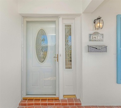 The oversized covered front porch welcomes you into this on Mainlands Golf Club in Florida - for sale on GolfHomes.com, golf home, golf lot