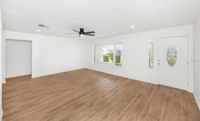 The oversized covered front porch welcomes you into this on Mainlands Golf Club in Florida - for sale on GolfHomes.com, golf home, golf lot