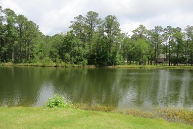 This lovely wooded, over a half acre, lot overlooks the 4th tee on Carolina National Golf Club in North Carolina - for sale on GolfHomes.com, golf home, golf lot