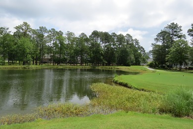 This lovely wooded, over a half acre, lot overlooks the 4th tee on Carolina National Golf Club in North Carolina - for sale on GolfHomes.com, golf home, golf lot