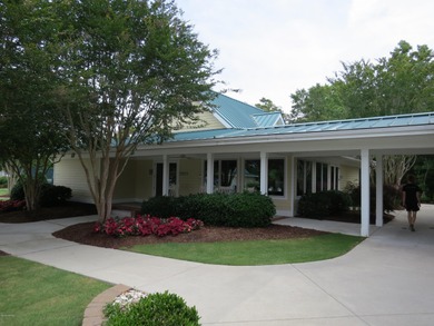 This lovely wooded, over a half acre, lot overlooks the 4th tee on Carolina National Golf Club in North Carolina - for sale on GolfHomes.com, golf home, golf lot