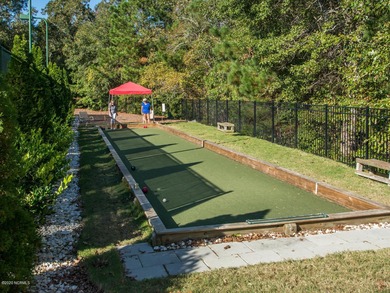 This lovely wooded, over a half acre, lot overlooks the 4th tee on Carolina National Golf Club in North Carolina - for sale on GolfHomes.com, golf home, golf lot