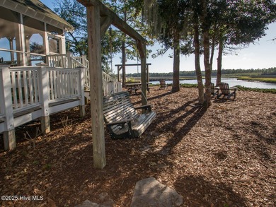 This lovely wooded, over a half acre, lot overlooks the 4th tee on Carolina National Golf Club in North Carolina - for sale on GolfHomes.com, golf home, golf lot