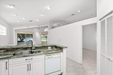 Lakefront single family home nestled amongst vibrant flowering on Westchester Golf and Country Club in Florida - for sale on GolfHomes.com, golf home, golf lot