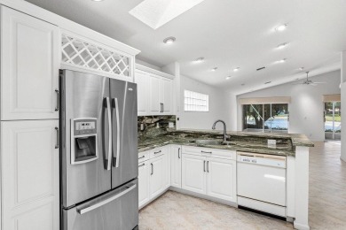 Lakefront single family home nestled amongst vibrant flowering on Westchester Golf and Country Club in Florida - for sale on GolfHomes.com, golf home, golf lot