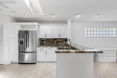 Lakefront single family home nestled amongst vibrant flowering on Westchester Golf and Country Club in Florida - for sale on GolfHomes.com, golf home, golf lot