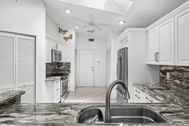 Lakefront single family home nestled amongst vibrant flowering on Westchester Golf and Country Club in Florida - for sale on GolfHomes.com, golf home, golf lot