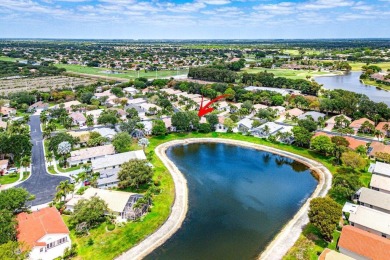 Lakefront single family home nestled amongst vibrant flowering on Westchester Golf and Country Club in Florida - for sale on GolfHomes.com, golf home, golf lot