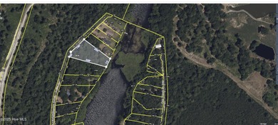 Just under an acre of waterfront property in the Sunset Lakes on Oyster Bay Golf Links in North Carolina - for sale on GolfHomes.com, golf home, golf lot