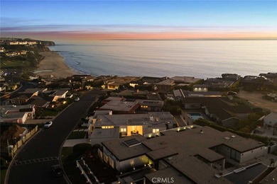 As waves break along Salt Creek Beach, evening lights shimmer on Monarch Beach Golf Links in California - for sale on GolfHomes.com, golf home, golf lot