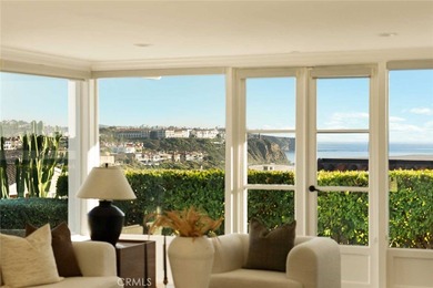 As waves break along Salt Creek Beach, evening lights shimmer on Monarch Beach Golf Links in California - for sale on GolfHomes.com, golf home, golf lot