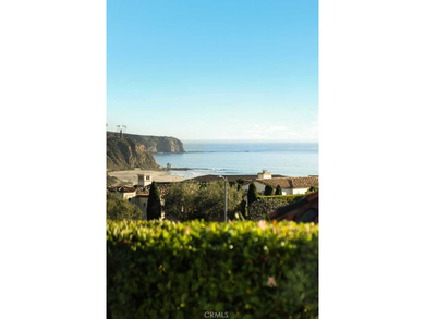 As waves break along Salt Creek Beach, evening lights shimmer on Monarch Beach Golf Links in California - for sale on GolfHomes.com, golf home, golf lot
