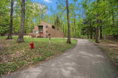 Nestled on a serene, wooded lot and backing up to protected on Birchwood Farms Golf and Country Club in Michigan - for sale on GolfHomes.com, golf home, golf lot