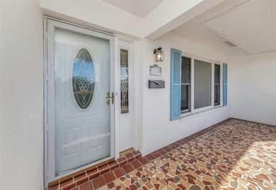The oversized covered front porch welcomes you into this on Mainlands Golf Club in Florida - for sale on GolfHomes.com, golf home, golf lot