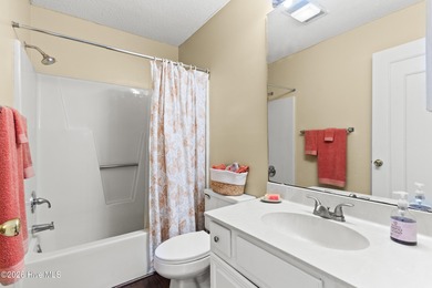 Set on a quiet street with peaceful views of Tradewinds Lake on Harbour Point Golf Club in North Carolina - for sale on GolfHomes.com, golf home, golf lot