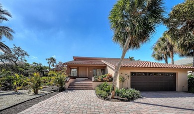 Wrapped in lush, mature landscaping and set along a tranquil on Longboat Key Golf Club Resort in Florida - for sale on GolfHomes.com, golf home, golf lot