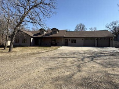 Nestled on a serene treed lot, this stunning one-story on Devils Lake Town and Country Club in North Dakota - for sale on GolfHomes.com, golf home, golf lot