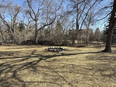 Nestled on a serene treed lot, this stunning one-story on Devils Lake Town and Country Club in North Dakota - for sale on GolfHomes.com, golf home, golf lot