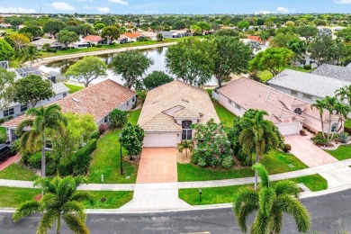 Lakefront single family home nestled amongst vibrant flowering on Westchester Golf and Country Club in Florida - for sale on GolfHomes.com, golf home, golf lot