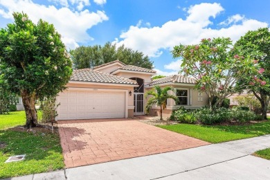 Lakefront single family home nestled amongst vibrant flowering on Westchester Golf and Country Club in Florida - for sale on GolfHomes.com, golf home, golf lot