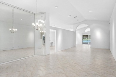Lakefront single family home nestled amongst vibrant flowering on Westchester Golf and Country Club in Florida - for sale on GolfHomes.com, golf home, golf lot