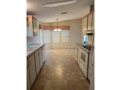 This home needs a little TLC and is priced at $25,000 for a on Pine Lakes Country Club in Florida - for sale on GolfHomes.com, golf home, golf lot