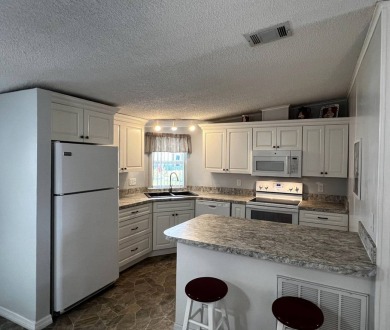 Welcome to your dream oasis! This stunning 2-bedroom, 2-bathroom on Lake Henry Golf Club in Florida - for sale on GolfHomes.com, golf home, golf lot