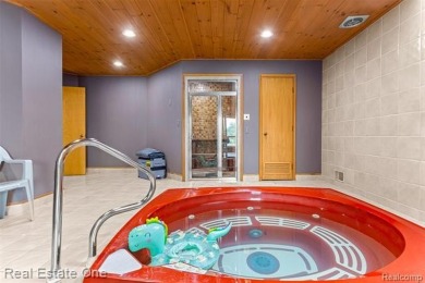 Experience refined contemporary living in this exquisite on Riverview Highlands Golf Club  in Michigan - for sale on GolfHomes.com, golf home, golf lot